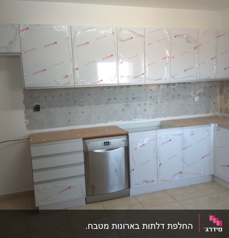 מטבח חדש עם ארונות מכוסים בניילון